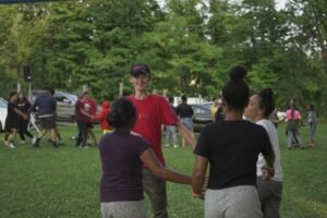 This is am image of a camp counselor teaching campers a choreographed dance routine.